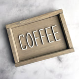 beige wood sign that says Coffee in white lettering on gray background