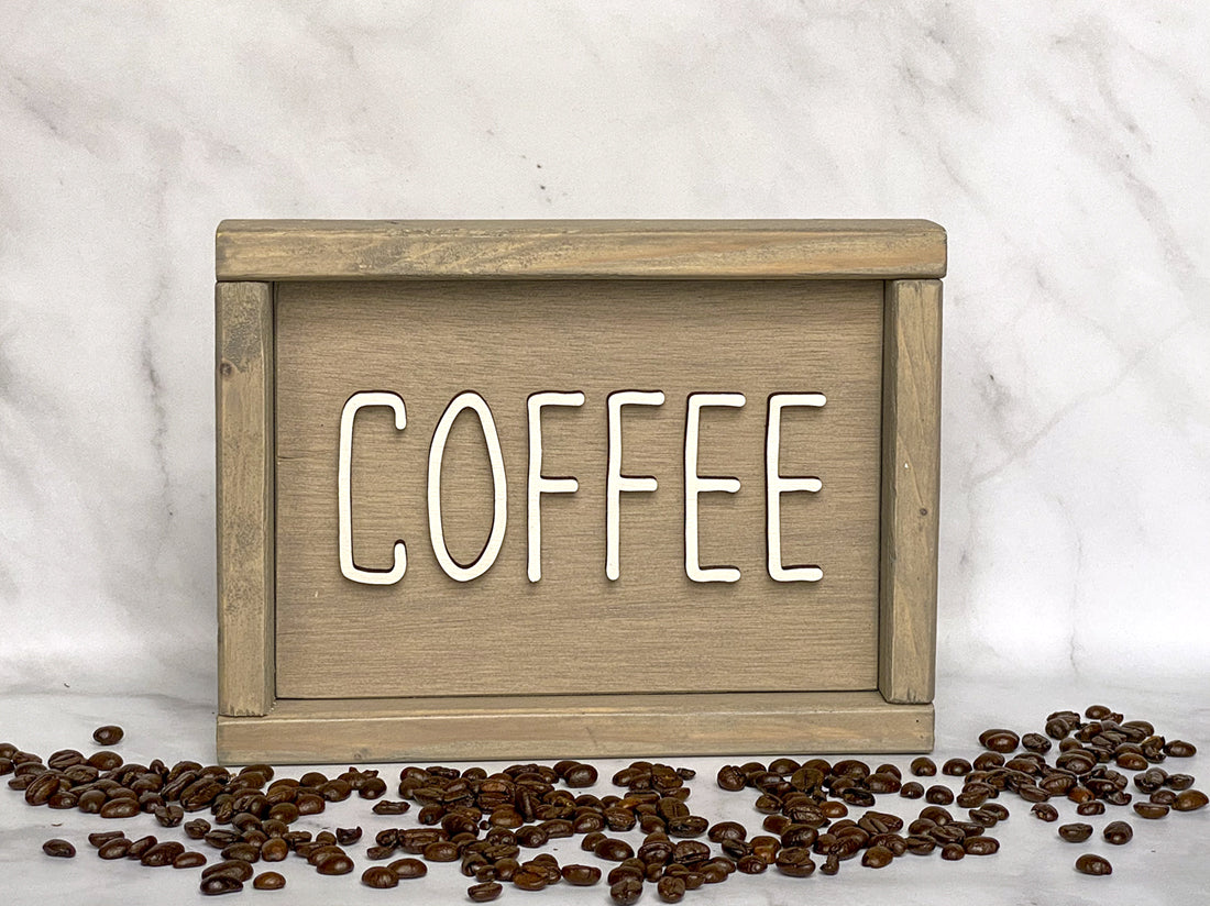 beige wood sign that says Coffee in white lettering with coffee beans around it