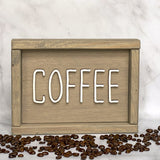 beige wood sign that says Coffee in white lettering with coffee beans around it