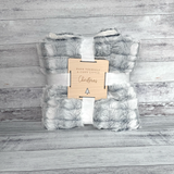 Soft blanket with a wooden tag on a wooden surface