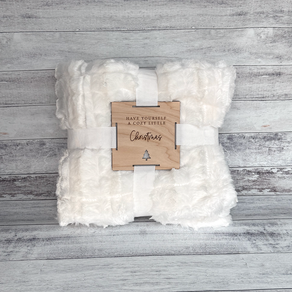 White blanket with a wooden tag on a wooden surface