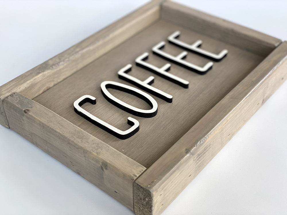 closeup of beige wood sign with coffee in white letters