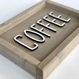 closeup of beige wood sign with coffee in white letters