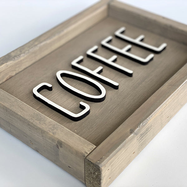 closeup of beige wood sign with coffee in white letters