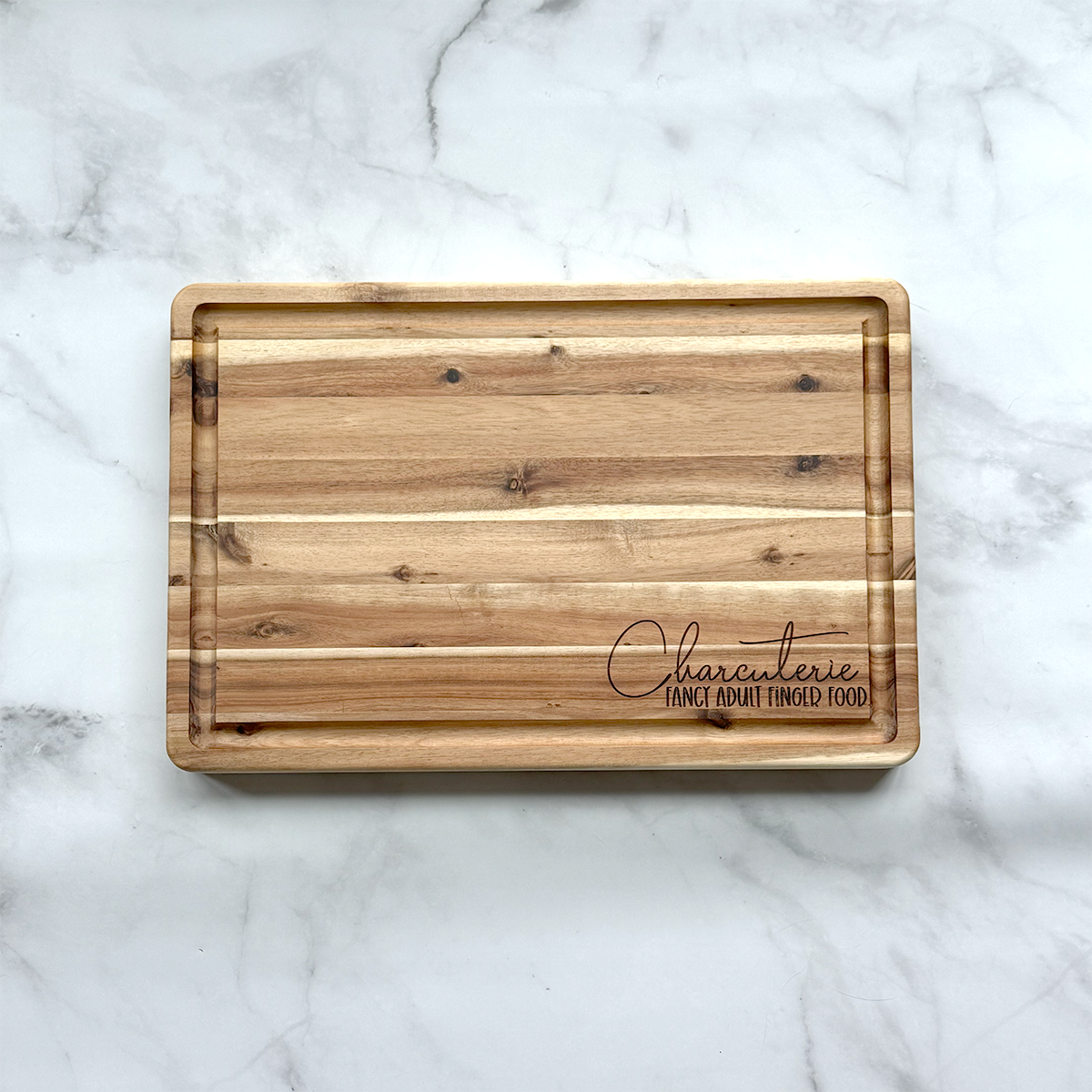Wooden cutting board with engraved text on a marble surface