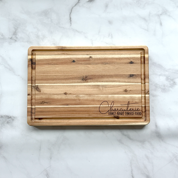Wooden cutting board with engraved text on a marble surface