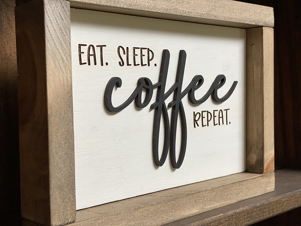 Closeup of Eat Sleep coffee repeat wood sign
