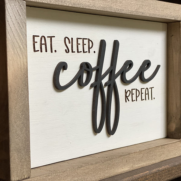 Closeup of Eat Sleep coffee repeat wood sign