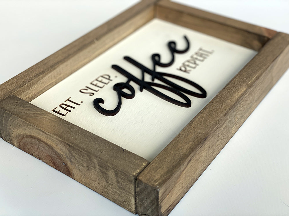 Side view of eat sleep coffee repeat wood sign