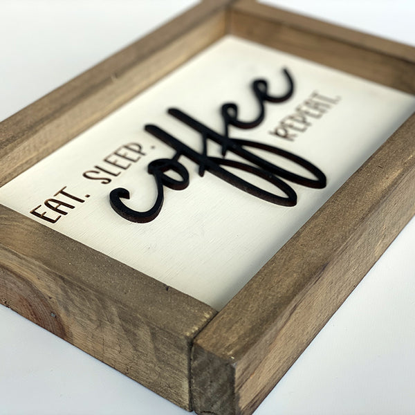 Side view of eat sleep coffee repeat wood sign