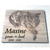 Wooden plaque with engraved image of a cat and text 'Maxine forever loved 2004-2022' on a white background