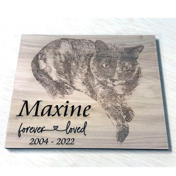 Wooden plaque with engraved image of a cat and text 'Maxine forever loved 2004-2022' on a white background