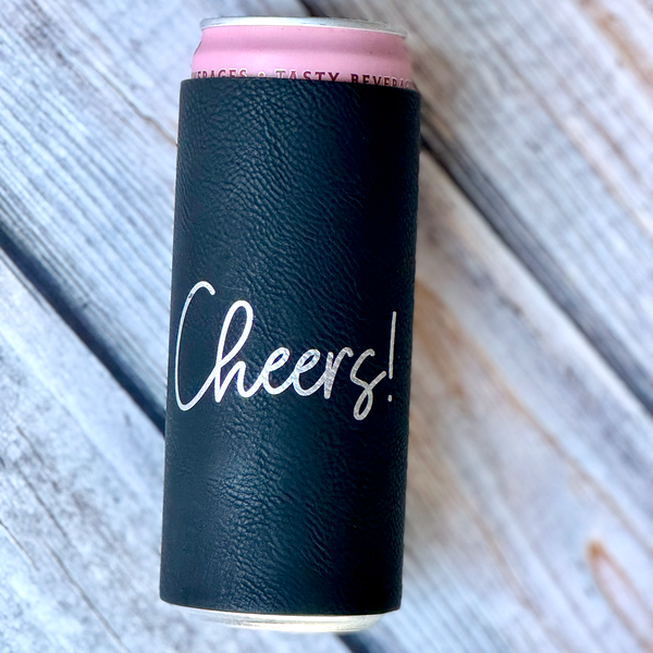 Can with a black sleeve that says 'Cheers!' on a wooden surface