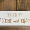 Closeup of fueled by Caffeine and Chaos wood sign