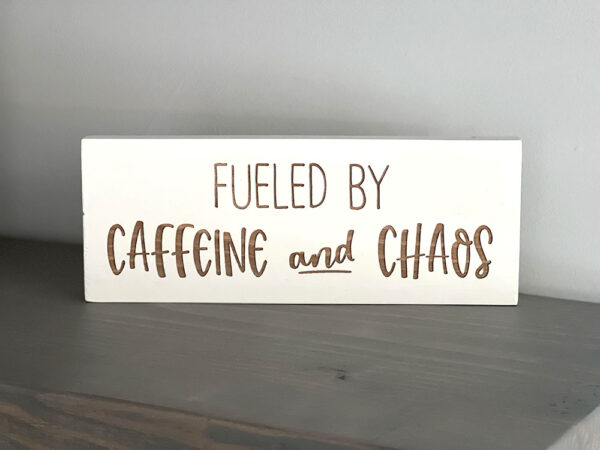 Fueled by caffeine and chaos wood sign on gray shelf