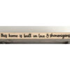 Closeup of This home is built on love & shenanigans wood sign