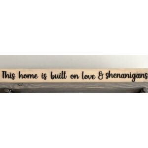 Closeup of This home is built on love & shenanigans wood sign